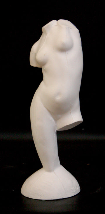 photo of plaster cast sculpture of female torso and right leg flowing into plaster base against black background