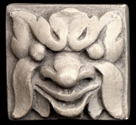Photo of square tile sculpture of happy face made of leaves