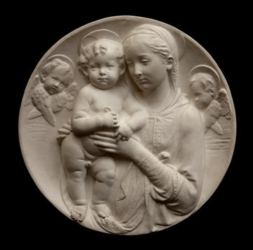 photo of plaster cast sculpture relief of the Madonna holding baby Jesus and angels in the background on a black background