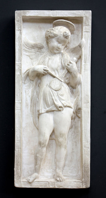 photo of plaster cast relief sculpture with angel playing a lyre on a dark gray background
