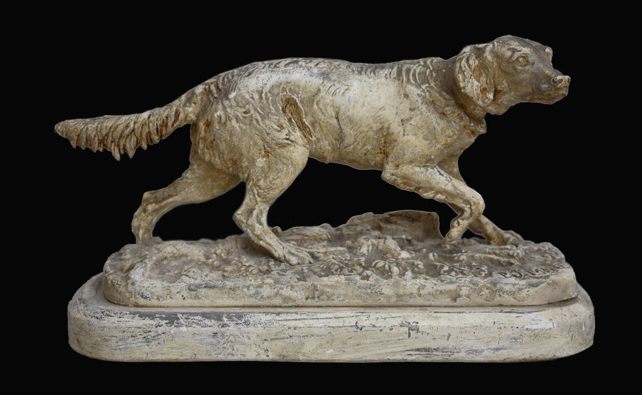 photo of plaster cast sculpture of dog walking on ground on a black background