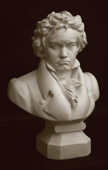 photo with black background of plaster cast sculpture of male bust of Ludwig van Beethoven in dress coat and ruffled necktie