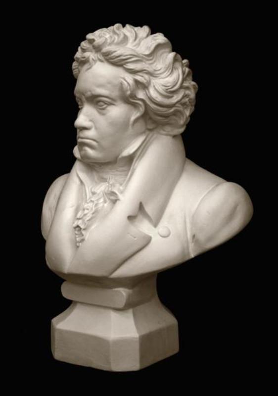 photo with black background of plaster cast sculpture of male bust of Ludwig van Beethoven in dress coat and ruffled necktie
