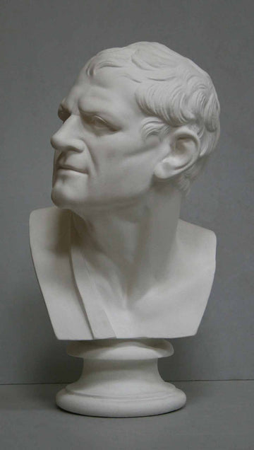 photo of plaster cast bust of man with head turned to his right and a sash on his right shoulder on a gray background