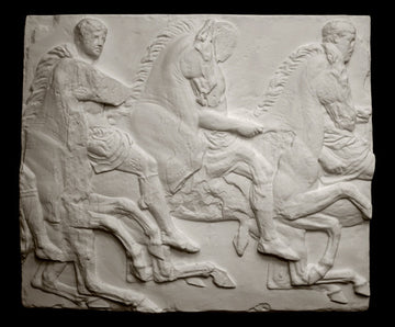 photo of off-white plaster cast relief sculpture of three men on horseback from Parthenon against black background