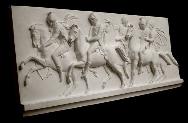 photo of plaster cast relief sculpture of men on horses against black background