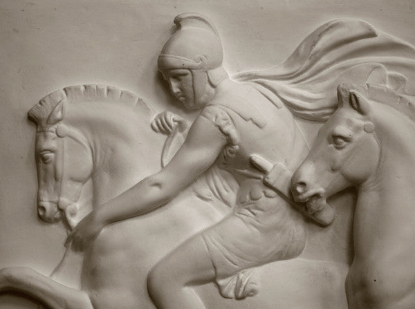 closeup photo of plaster cast relief sculpture showing one man on horse against black background