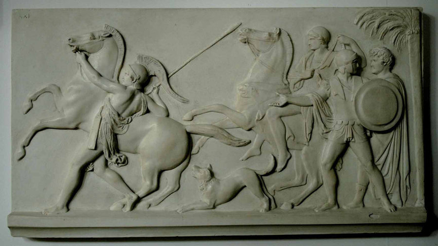 photo of plaster cast relief of men, some with armor, horses, and a dog on a tan-colored wall