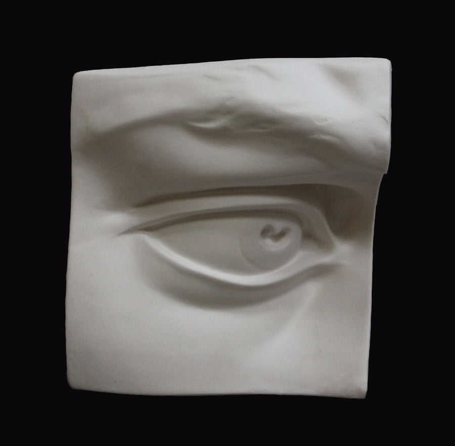 Photo of plaster cast sculpture of right eye on panel from Michelangelo's David statue on a black background