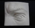 Photo of plaster cast sculpture of portion of face with left eye  from Michelangelo's David statue on a black background