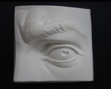 Photo of plaster cast sculpture of portion of face with left eye  from Michelangelo's David statue on a black background