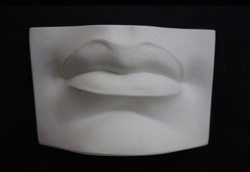 photo with black background of plaster cast of sculpted mouth