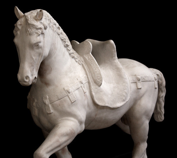 Photo of a sculpture of a plaster horse on a black background