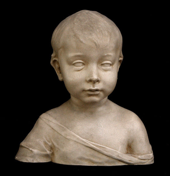 photo of plaster cast sculpture of boy from shoulders up with light tunic slipping off left shoulder with black background