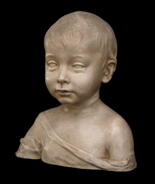 photo of plaster cast sculpture of boy from shoulders up with light tunic slipping off left shoulder with black background