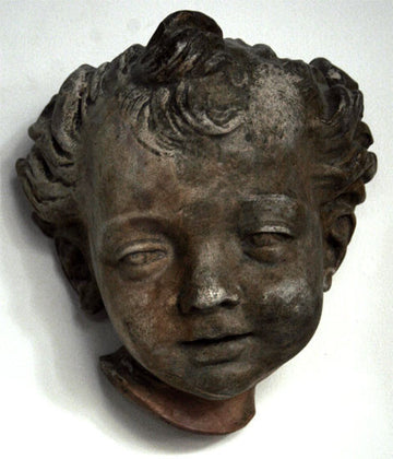 photo of bronze-colored plaster cast sculpture of child's face on white background