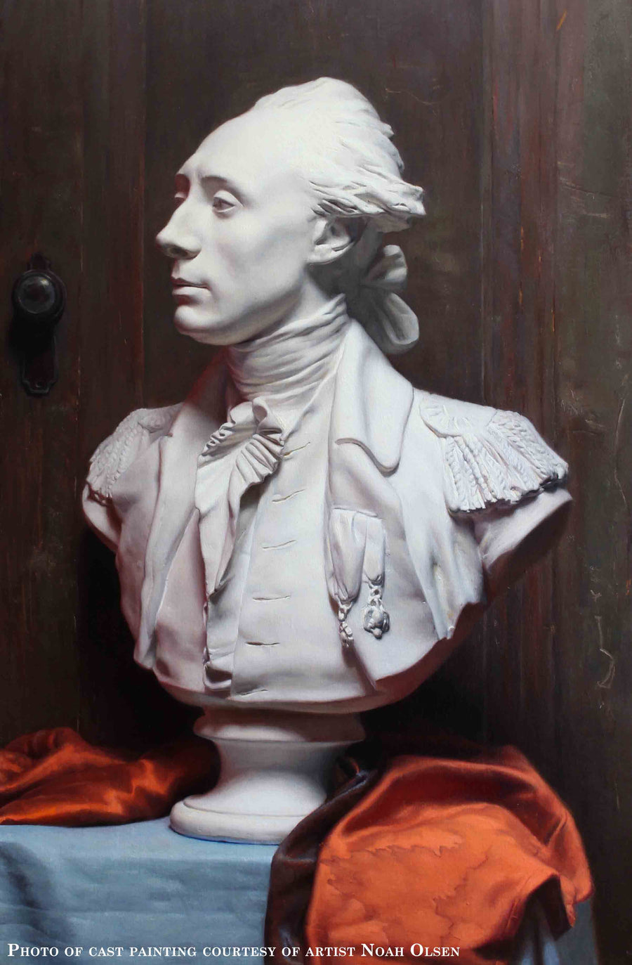 Photo of Cast Painting of Plaster Cast of Lafayette on a blue table with a red cloth and dark wooden background