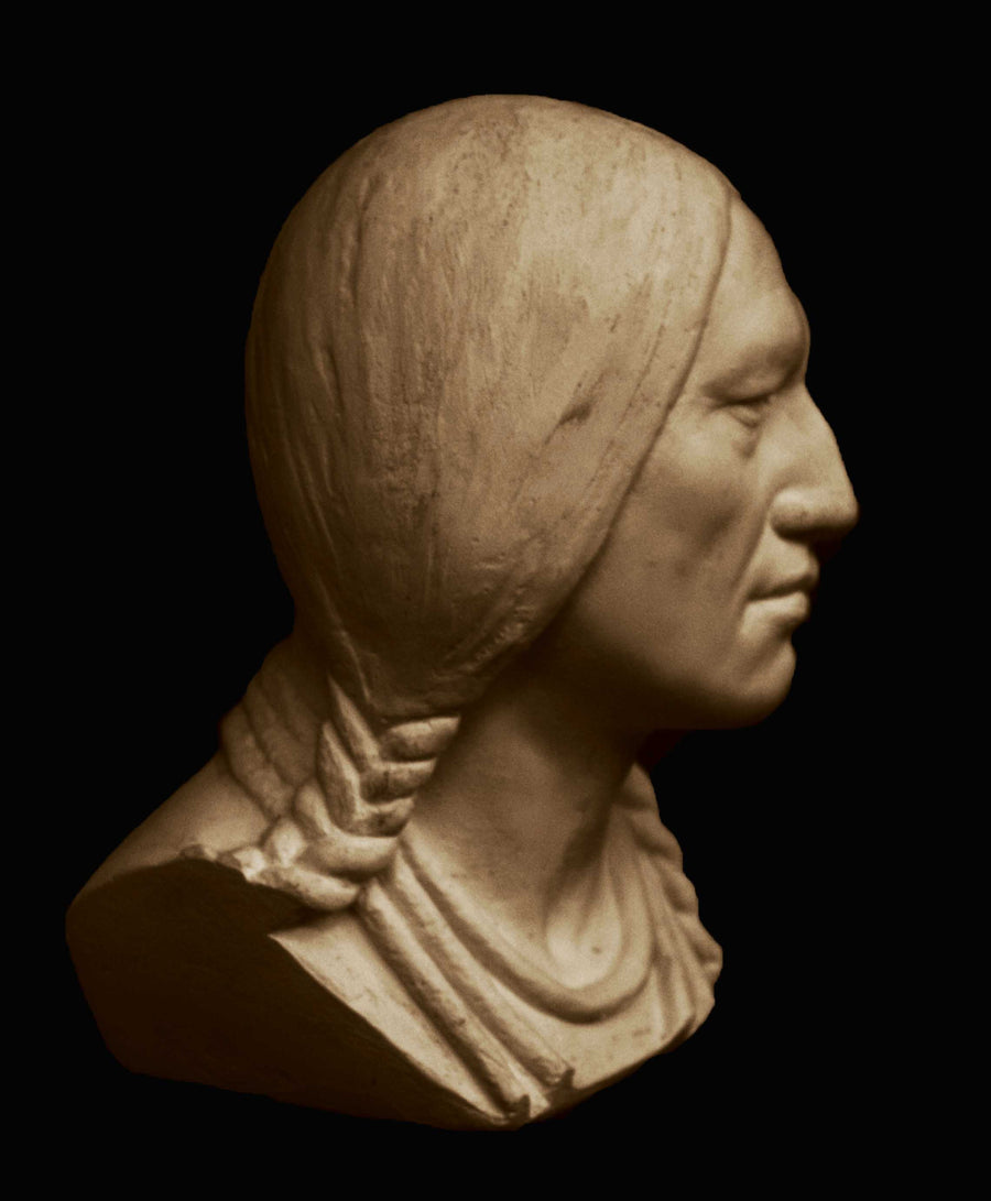 photo with black background of plaster cast sculpture of male head of Massasoit with braids and necklaces