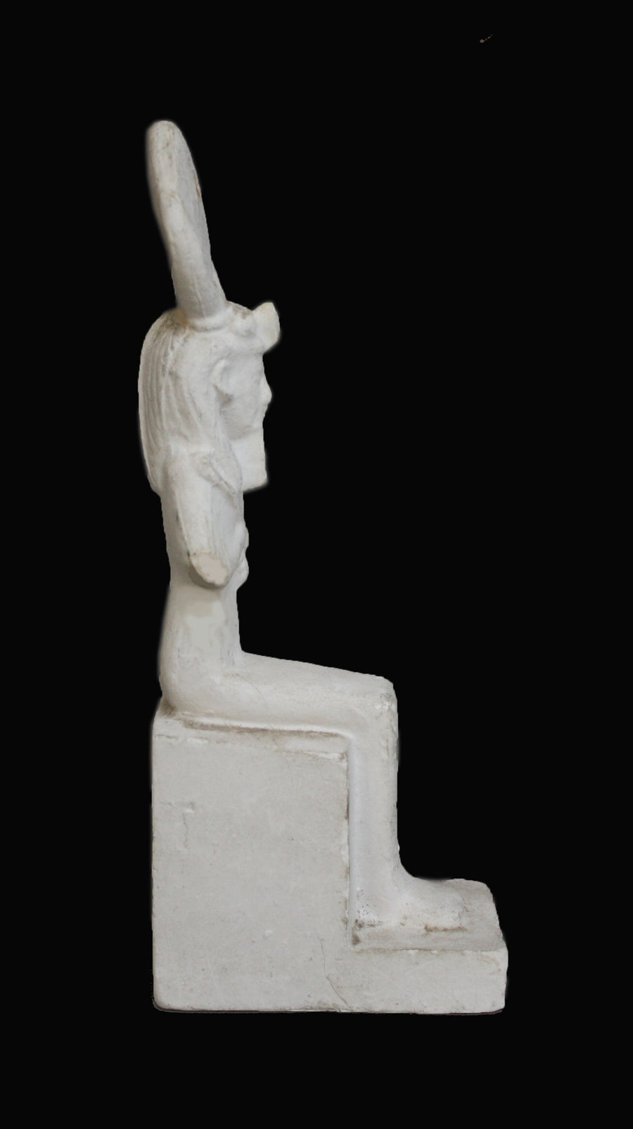 photo with black background of plaster cast sculpture of Egyptian mummy seated